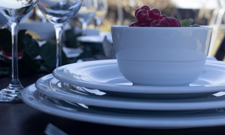 Porcelana Costa Verde: mesa con platos y tazon con uvas de la Colección Agma