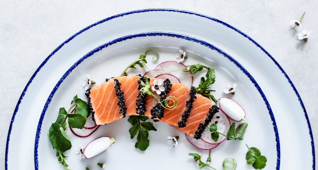 Salmon, radishes and edible flowers’ platting, on a plate from the Coral collection