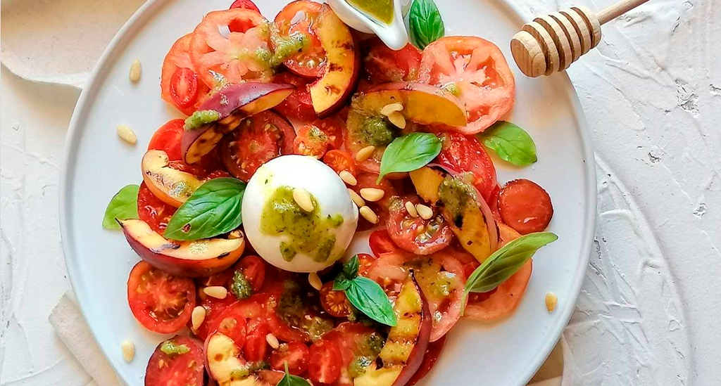 Salada com nectarina, tomate e outros ingredientes, servida num prato da coleção Nordika